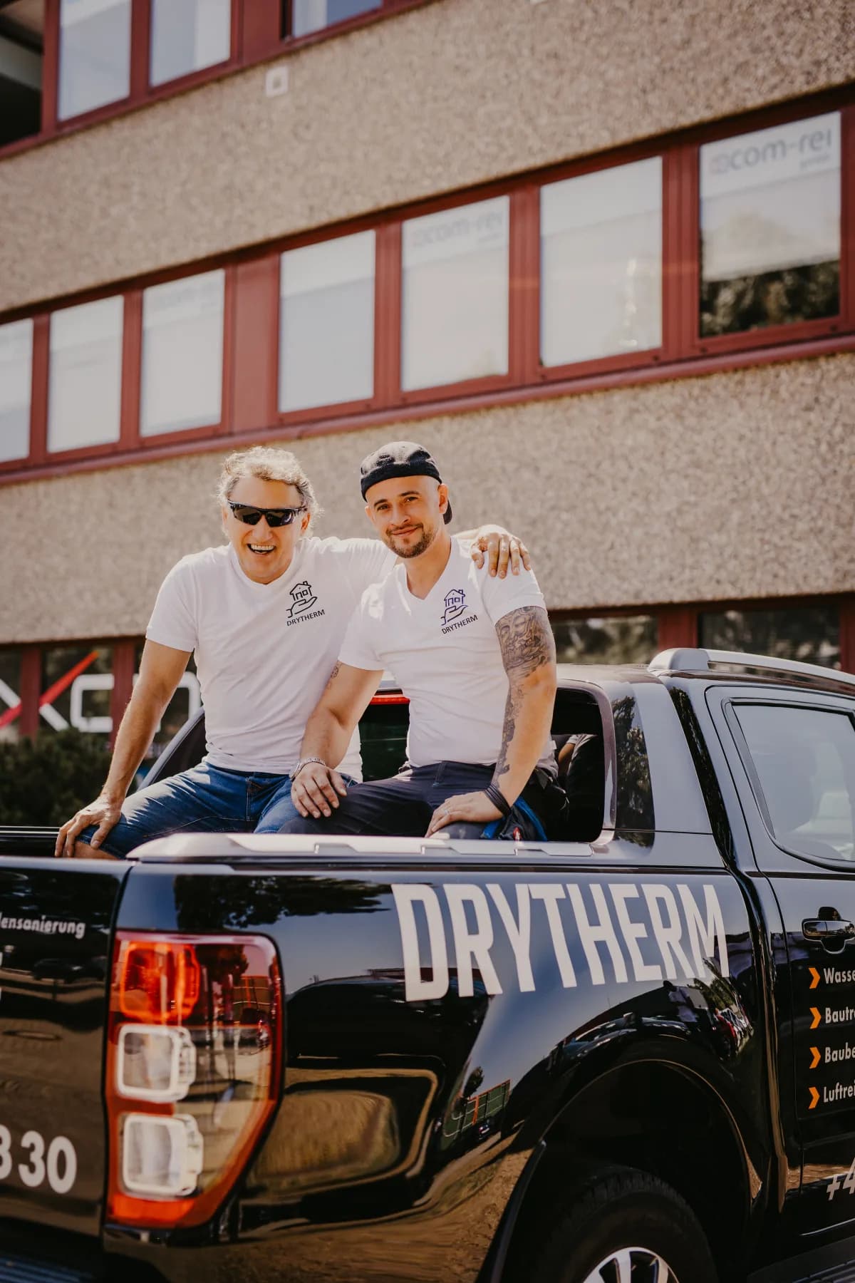 Zwei Drytherm-Mitarbeiter auf der Ladefläche des Firmen-Pickups
